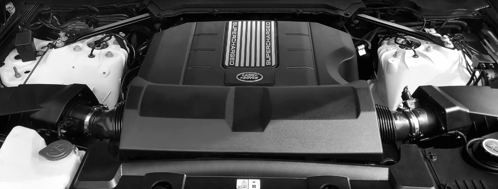 Close-up of a supercharged Land Rover engine bay, showcasing the clean and powerful engine layout often addressed for Land Rover issues at Advanced European Repair in Franklin, MA.
