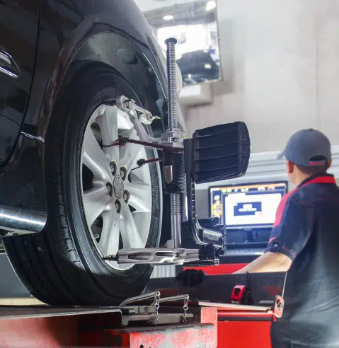 Tires and alignment services in Franklin, MA, at Advanced European Repair. Image of a technician doing tire and alignment check on a vehicle.