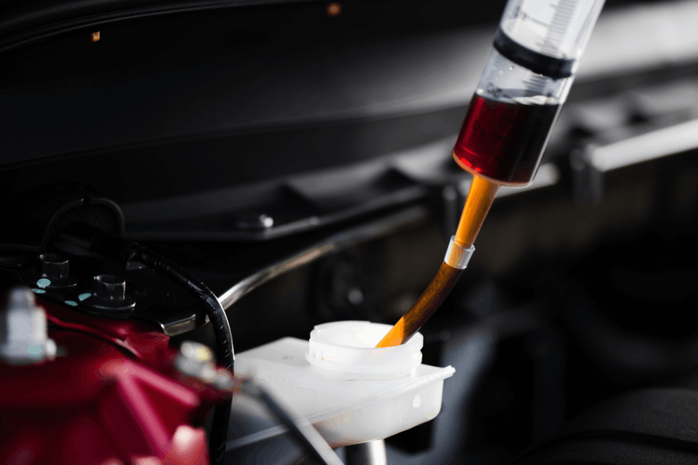 Brake fluid flush, European auto repair in Franklin, MA at Advanced European Repair. Image of old brake fluid being extracted from a vehicle’s brake fluid reservoir during professional maintenance.